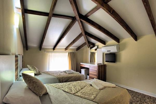 Doppelzimmer im Sahra Su Holiday Village & Spa mit zwei Betten und Holzdecken.