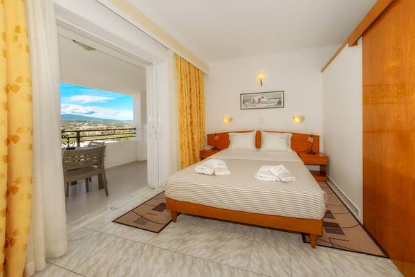 Schlafzimmer des Zante Palace Hotels mit Blick auf einen Balkon und eine Terrasse.