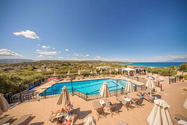 Aussicht auf den Poolbereich des Zante Palace Hotels mit Sonnenliegen, Schirmen und Blick auf das Meer.