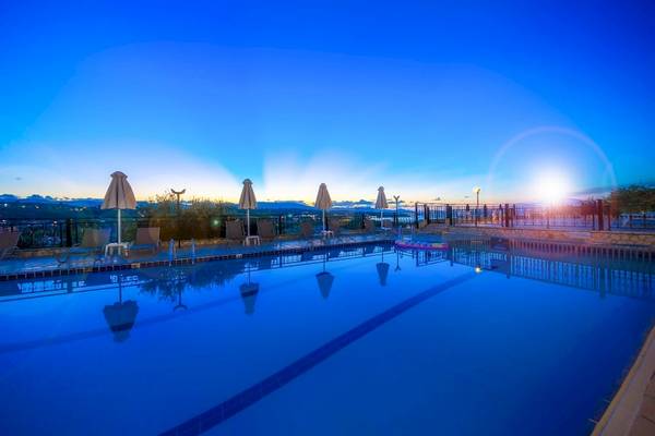 Pool des Zante Palace Hotels bei Sonnenuntergang mit geöffneten Sonnenschirmen und Liegestühlen