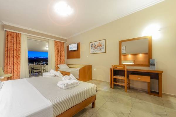 Innenansicht eines Zimmers im Zante Palace Hotel mit Bett, Schreibtisch und Aussicht auf den Garten.