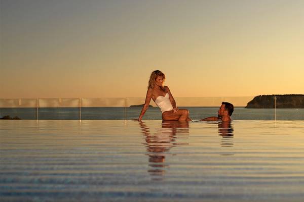 Ein Paar entspannt sich im Pool des Dubrovnik President Valamar Collection Hotels bei Sonnenuntergang.