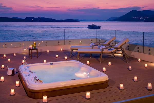 Terrasse mit Whirlpool und Kerzen bei Abendstimmung mit Blick aufs Meer