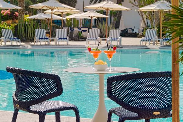 Cocktails am Pool des Seaside Los Jameos Hotels mit Sonnenschirmen und Stühlen im Hintergrund.