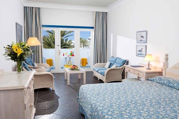 Innenansicht eines Schlafzimmers im Seaside Los Jameos Hotel mit Blick auf einen Balkon.
