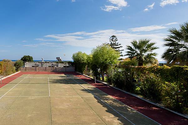 Tennisplatz im Olympos Beach Resort mit blauem Himmel und Palmen