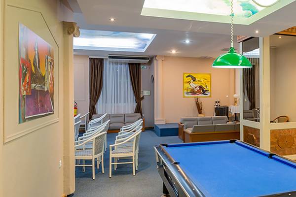Pooltisch im Aufenthaltsbereich des Olympos Beach Resorts mit Sofas und Stühle.