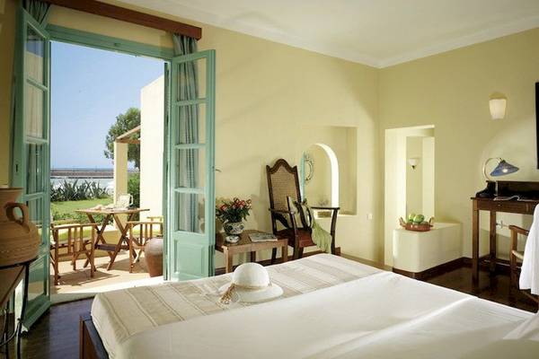 Zimmer im Kalimera Kriti Hotel & Village Resort mit Blick auf die Terrasse und den Garten.