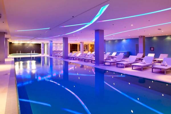 Poolbereich im Radisson Blu Resort Split mit blauen Lichtern und weißen Liegestühlen.