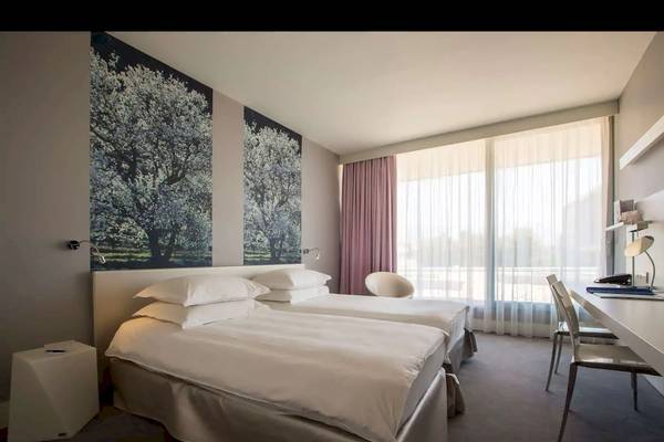 Hotelzimmer im Radisson Blu Resort Split mit zwei Betten und modernen Möbeln.