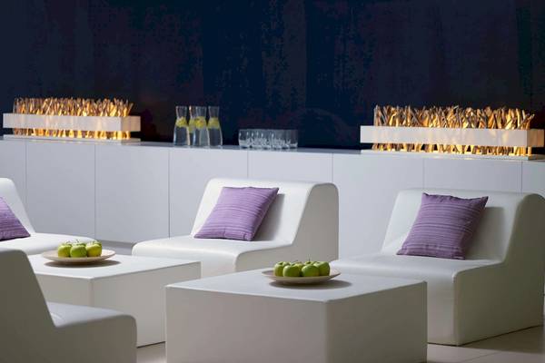 Lounge-Bereich im Radisson Blu Resort Split mit weißen Möbeln, grünen Äpfeln auf Tischen und brennenden Kaminen.
