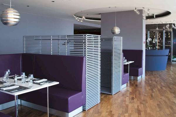 Innenraum des Radisson Blu Resort Split mit violetten Sitzbänken und hölzernem Boden.