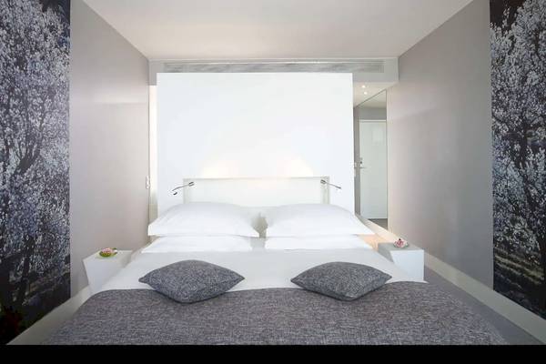 Schlafzimmer im Radisson Blu Resort Split mit zwei Betten, weißen Kissen und grauen Kissenbezügen.