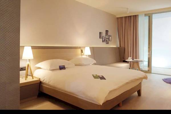 Hotelzimmer im Radisson Blu Resort Split mit Doppelbett, Nachttischen und Lampen.