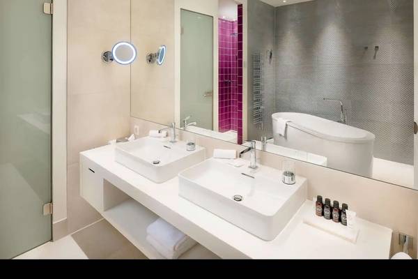 Badezimmer im Radisson Blu Resort Split mit zwei Waschbecken, Badewanne und Dusche.