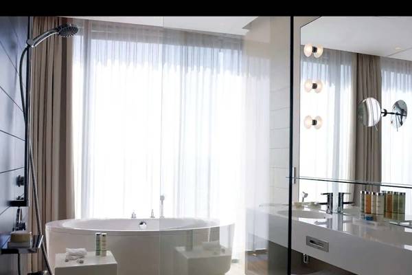Badezimmer im Radisson Blu Resort Split mit Badewanne und Spiegel.