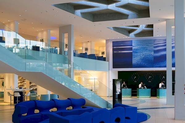 Lobby des Radisson Blu Resorts Split mit blauen Möbeln, Rezeption und großem Wandbild.