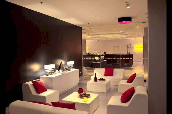 Innenansicht der Lobby des Radisson Blu Resort Split mit weißen Möbeln und roten Kissen.