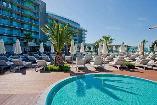 Außenbereich des Radisson Blu Resorts Split mit Swimmingpool, Liegestühlen und Sonnenschirmen.