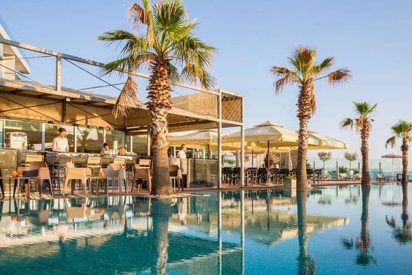 Außenpoolterrasse im Radisson Blu Resort Split mit Palmen und Sonnenschirmen.