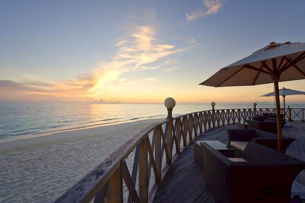 Terrasse des Angaga Island Resort & Spa mit Blick auf den Sonnenuntergang am Meer