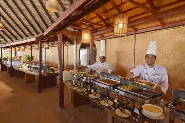 Restaurant im Angaga Island Resort & Spa mit Buffettischen, wo zwei Köche stehen und lächeln.