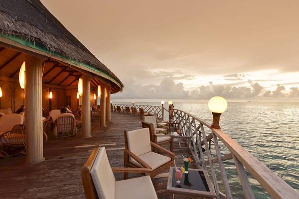 Terrasse des Angaga Island Resorts und Spas bei Sonnenuntergang mit Blick auf das Meer.