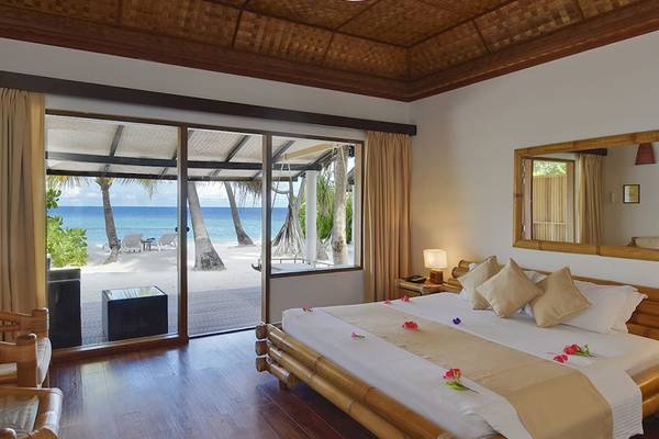 Schlafzimmer im Angaga Island Resort & Spa mit Meerblick, großen Schiebetüren und einem großen Bett.
