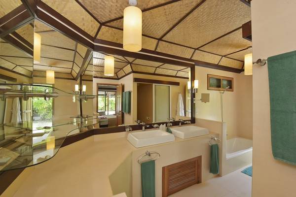 Badezimmer im Angaga Island Resort & Spa mit zwei Waschbecken, Spiegel und Badewanne.