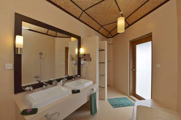 Badezimmer im Angaga Island Resort & Spa mit zwei Waschbecken, einem Spiegel und einer Dusche.