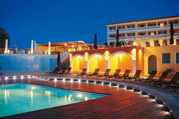 Poolbereich des Tsamis Zante Spa Resorts bei Nacht mit leuchtenden Lounge-Sesseln und einer blauen Poolbeleuchtung.