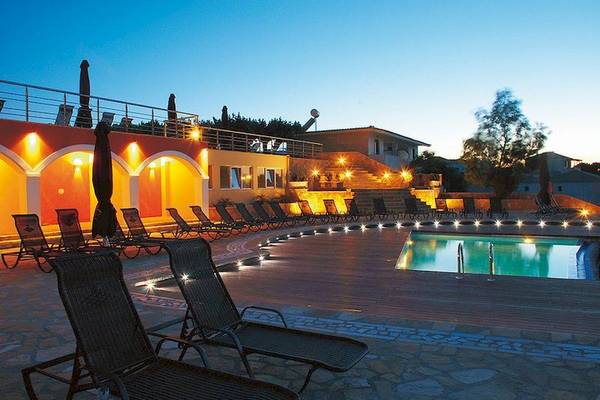 Abendansicht des Poolbereichs des Tsamis Zante Spa Resorts mit illuminierten Loungestühlen und Schwimmbad