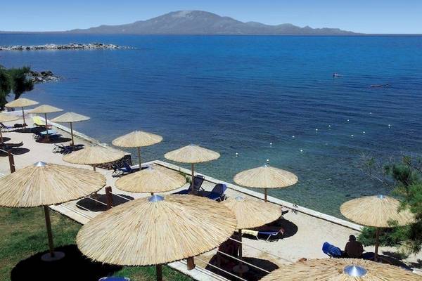Strandansicht des Tsamis Zante Spa Resorts mit vielen Sonnenschirmen und Liegen am Meer.