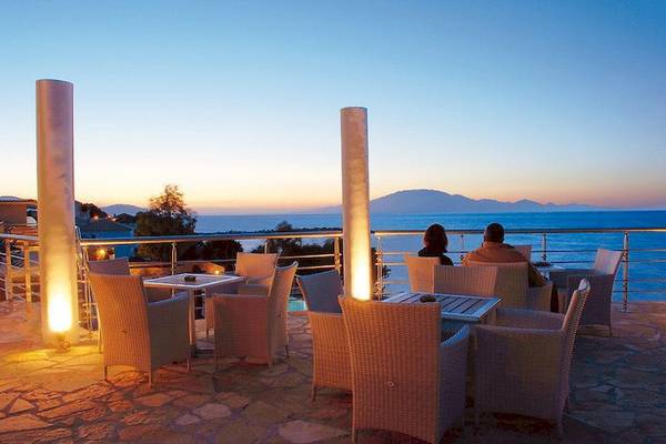 Zwei Personen sitzen auf der Terrasse des Tsamis Zante Spa Resorts und genießen die Aussicht auf das Meer.