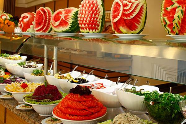 Cenger Beach Resort & Spa Buffet mit verschiedenen Wassermelonen-Skulpturen und vielen Salat- und Gemüseschüsseln.