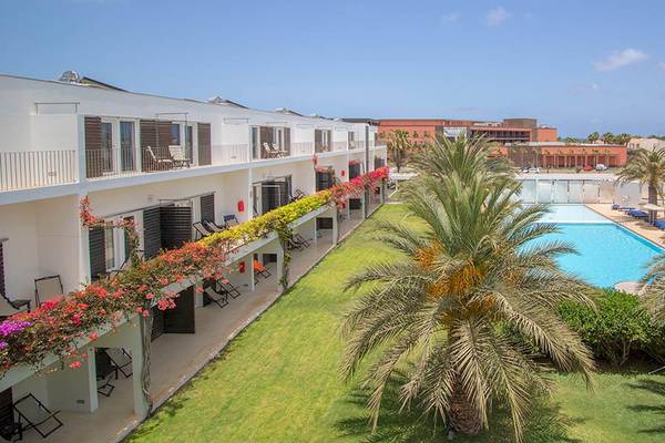 Außenbereich des Dunas De Sal Hotels mit Swimmingpool und Palme