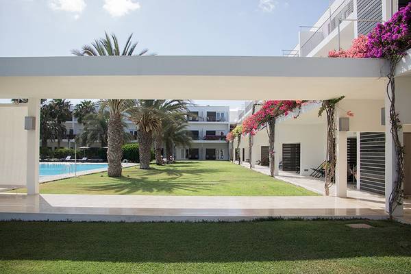Außenbereich des Dunas De Sal Hotels mit Swimmingpool und Palmen.