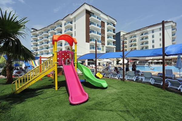 Spielplatz am Pool des Cenger Beach Resort & Spa mit bunten Rutschen und Sonnenschirmen.