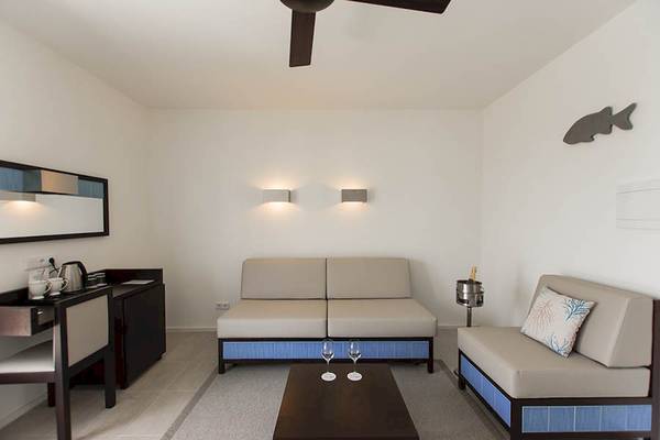 Wohnbereich im Dunas De Sal Hotel mit Sofa, Couch, Tisch und Schreibtisch.