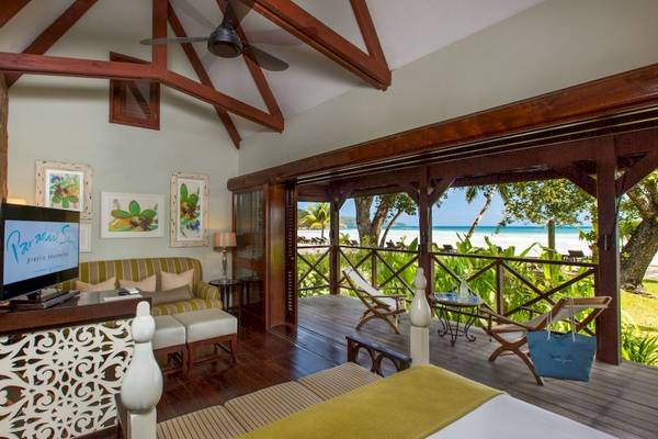 Aussicht auf den Strand aus dem Zimmer des Paradise Sun Hotels mit Balkon, Fernseher und Couch.