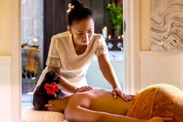 Massage im Paradise Sun Hotel, wo eine Therapeutin eine Rückenmassage an einer Frau durchführt.