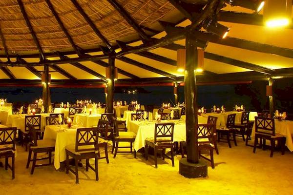 Restaurantbereich im Paradise Sun Hotel mit abendlicher Beleuchtung und gedeckten Tischen.