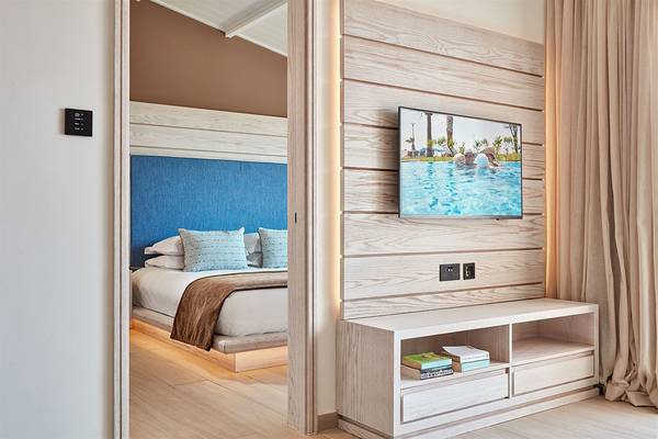 Innenansicht eines Zimmers im Mare Ayia Napa Hotel mit Bett, Fernseher und offenem Eingang.