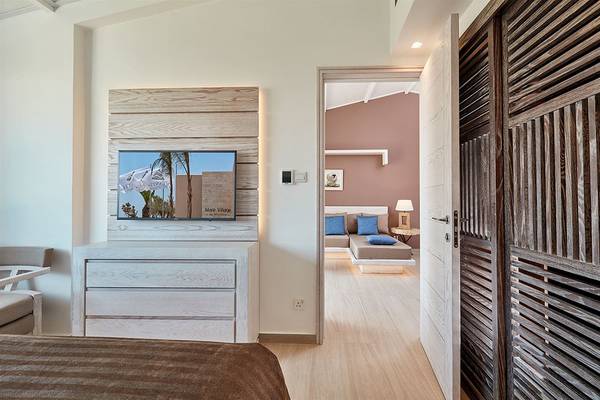 Innenansicht eines Zimmers im Mare Ayia Napa Hotel mit Fernseher und offenen Türen.