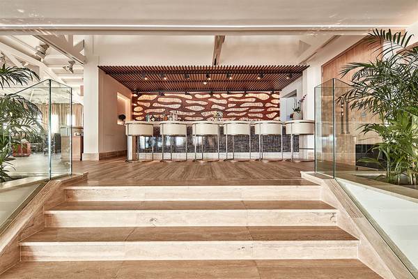 Lobby-Barbereich des Mare Ayia Napa Hotels mit Marmorboden und Glastrennwänden.
