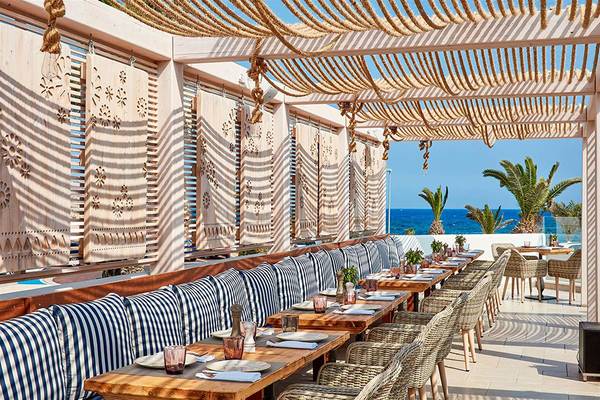 Hotelterrasse des Mare Ayia Napa mit Blick auf das Meer und Palmen.