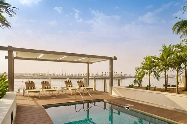 Pool-Bereich im Grand Hyatt Abu Dhabi Hotel mit Lounge-Sesseln und Wasserblick.