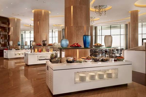 Innenbereich des Grand Hyatt Abu Dhabi Hotel mit Buffet, Vasen und Tischdekoration.