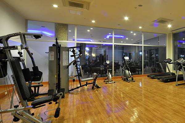 Fitness-Center im Cenger Beach Resort & Spa mit verschiedenen Trainingsgeräten und großen Fenstern.