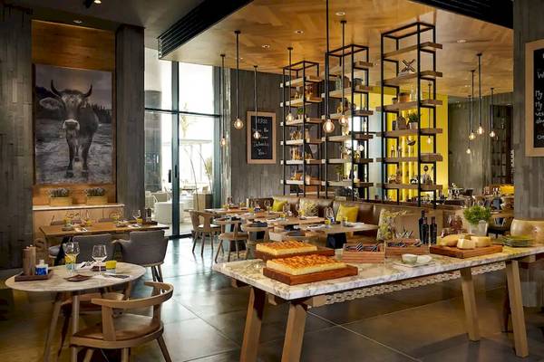 Restaurant-Innenansicht des Grand Hyatt Abu Dhabi Hotel mit Tischen, Stühlen und Speisen.